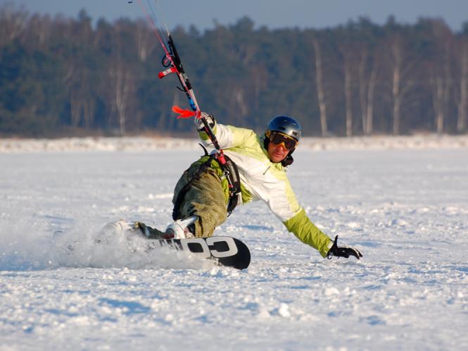 Zimą można spotkąć Tomka na zamarźniętej zatoce ścigającego się na snowkite